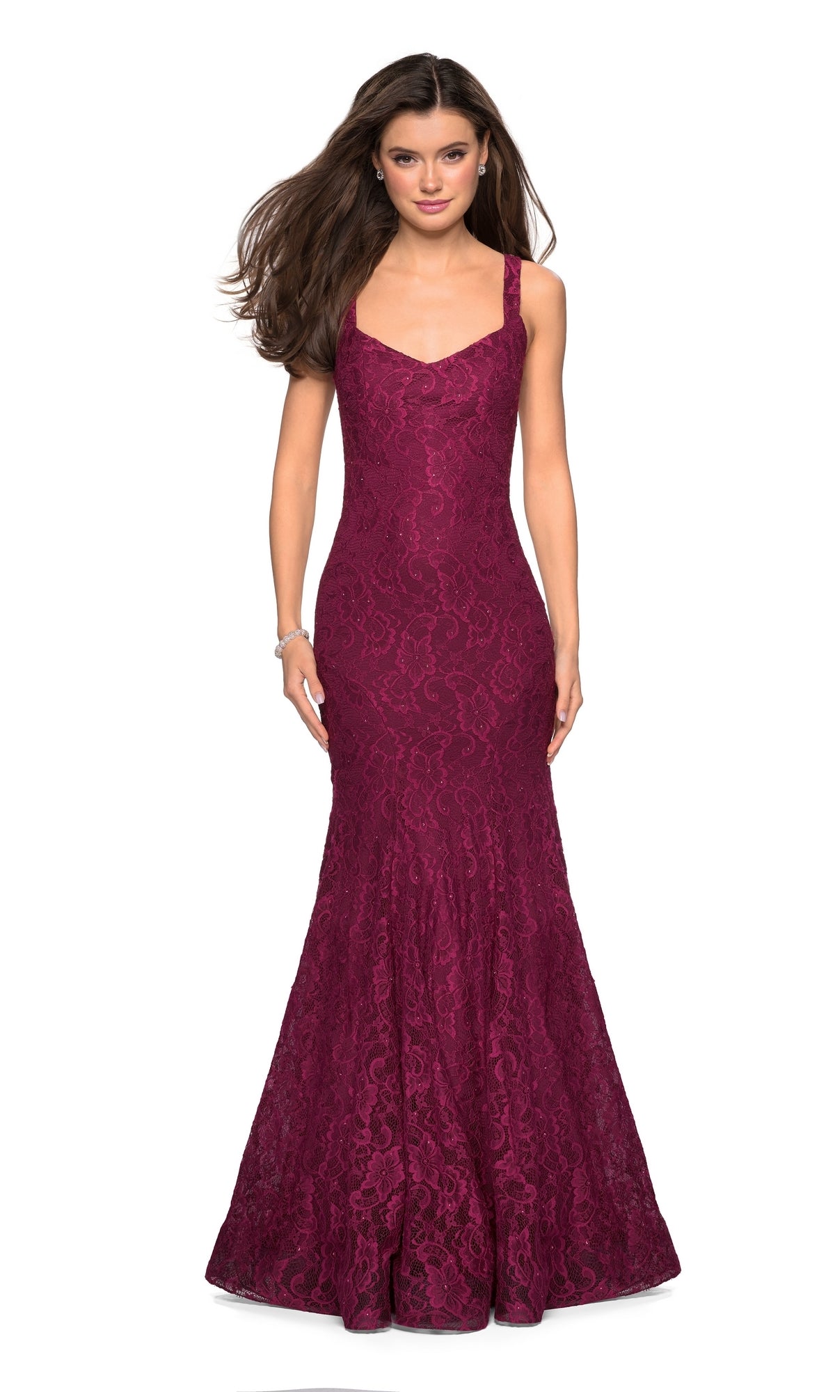 A woman models the La Femme 27709 open-back lace mermaid prom dress—sleeveless, fitted, and floor-length in burgundy—standing against a plain white background.